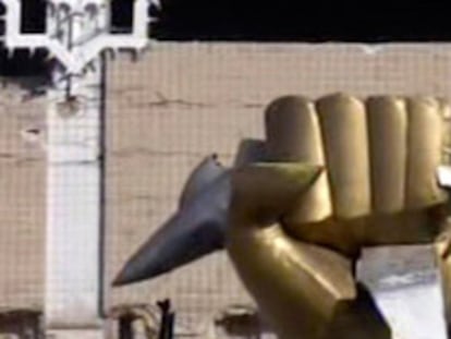 Un rebelde libio se sube a una estatua dentro del palacio de Gadafi, en Trípoli.
