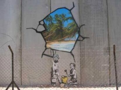 Grafiti realizado por Banksy en el muro