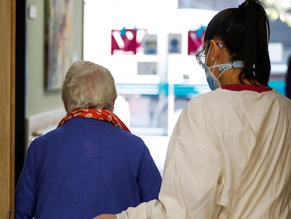 Una trabajadora ayuda a una paciente de la residencia de mayores Vitalia Canillejas, donde se ejercitan terapias para ganar autonomía frente a las secuelas del aislamiento.