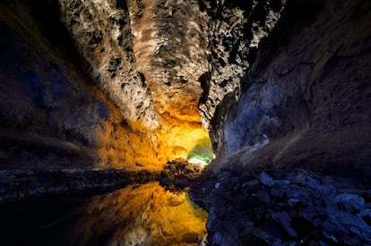 Un espejismo aguarda al final de la Cueva de los Verdes, el tubo de lava de siete kilómetros de largo que abrió hace cinco mil años en la isla canaria de Lanzarote la erupción del volcán Corona. El itinerario que la recorre enlaza tres galerías superpuestas y llega hasta el lago de la foto, donde el reflejo de la bóveda de piedra sobre el agua hace que parezca una sima inmensa.