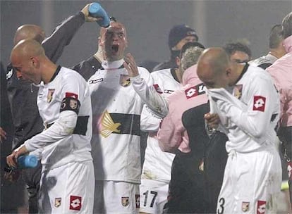 Los jugadores del Palermo se refrescan para protegerse del humo de las bengalas y de los gases lanzados por los policías italianos.