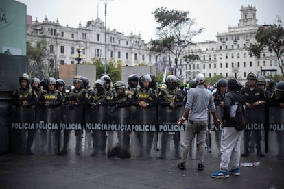 Protestors face riot police in Lima on December 16.