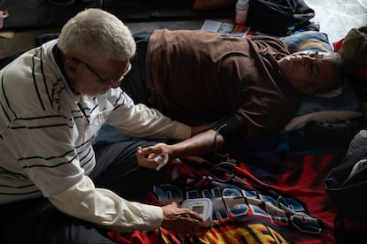 Dos hombres se toman mutuamente la presión arterial.