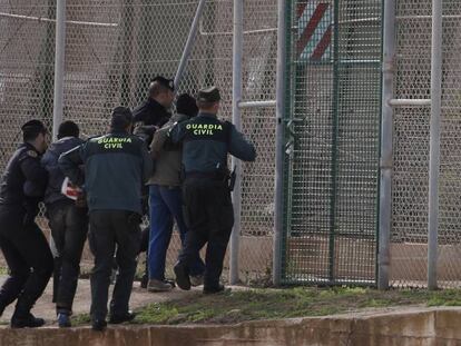 Agentes de la Guardia Civil expulsan por la valla de Melilla a dos inmigrantes subsaharianos que habían participado en un salto a la valla de Melilla en 2014.
