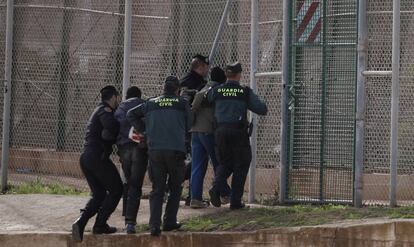 Agentes de la Guardia Civil expulsan por la valla de Melilla a dos inmigrantes subsaharianos que habían participado en un salto a la valla de Melilla en 2014.