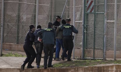 Agentes de la Guardia Civil expulsan por la valla de Melilla a dos inmigrantes subsaharianos que habían participado en un salto a la valla de Melilla en 2014.