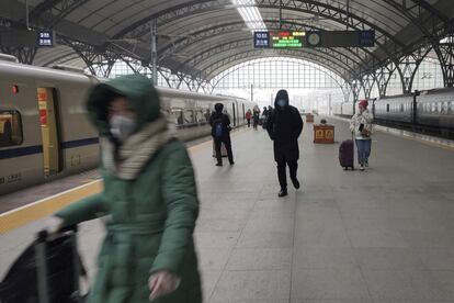 Viajeros con mascarilla en el andén de la estación de tren de Hankou, este jueves, poco antes del cierre de la ciudad de Wuhan. La medida afecta a todos los vuelos, trenes, autobuses y al metro.