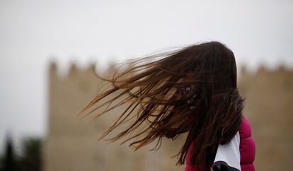 Una joven camina este martes en Córdoba, en una jornada muy ventosa.