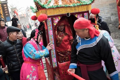 Chineses carregam uma mulher vestida de noiva, como parte do festival Sue Huo, que celebra o início do Ano do Cachorro em Hancheng, na China.