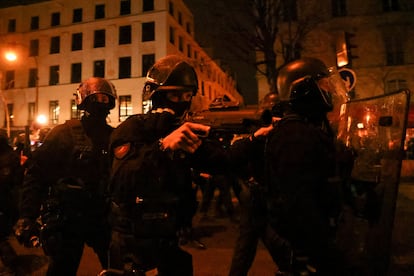 Un miembro de la policía antidisturbios sostiene un arma de fuego durante los disturbios en París, este jueves.