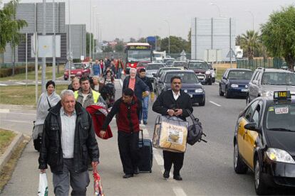Varios viajeros dirigiéndose a pie hacia el aeropuerto debido al colapso circulatorio.