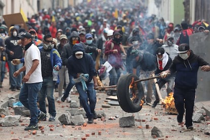 Los manifestantes llevan un neumático en llamas para formar una barricada, durante una protesta contra las medidas del presidente Lenin Moreno, en Quito (Ecuador). 