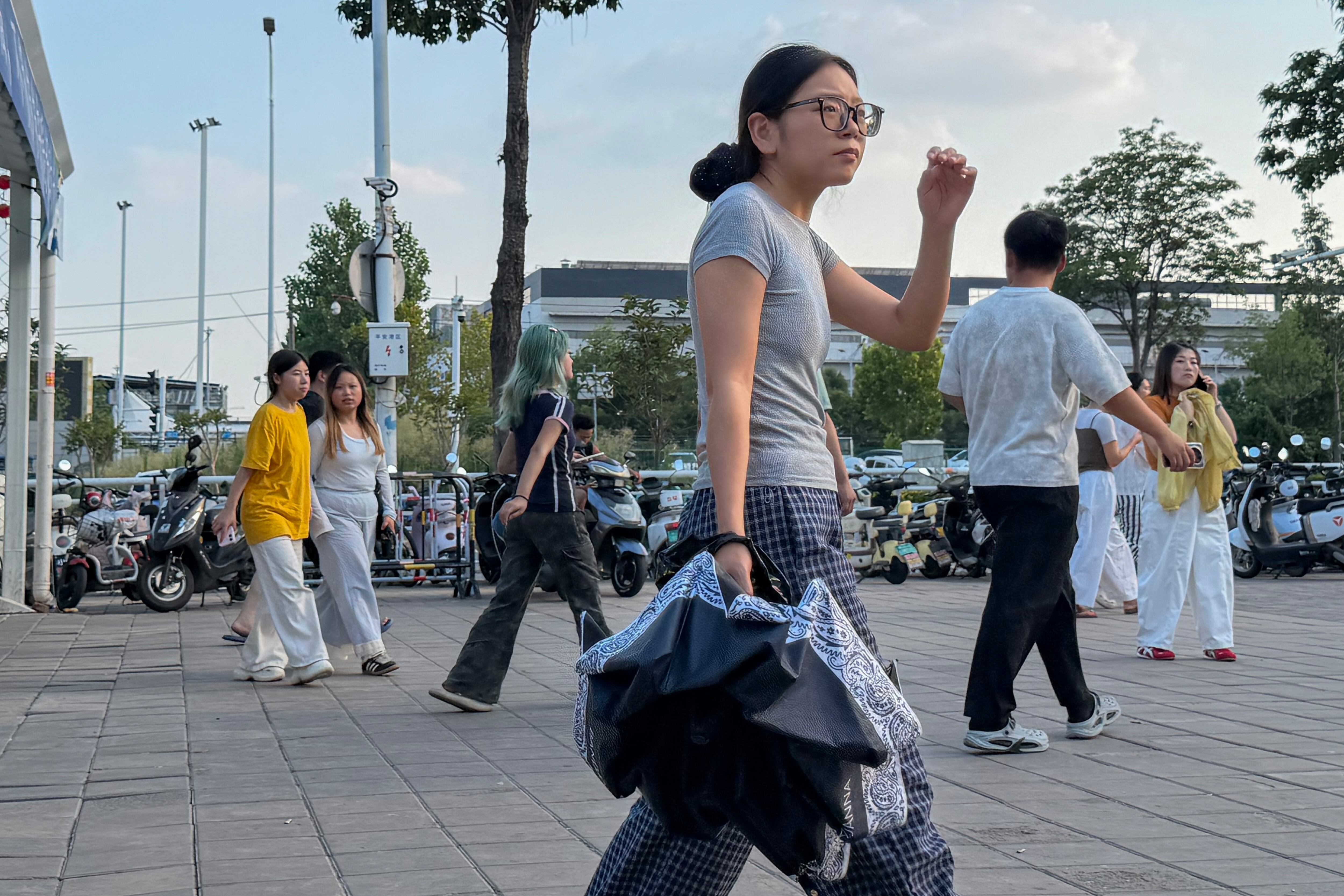 Trabajadores jóvenes a la salida de su turno en la fábrica de Foxconn, en Zhengzhou, China, el 7 de julio de 2026.