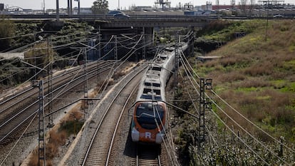 Un tren de Rodalies de la linia R2 circula por las vías del tren a su paso por la Zona Franca.