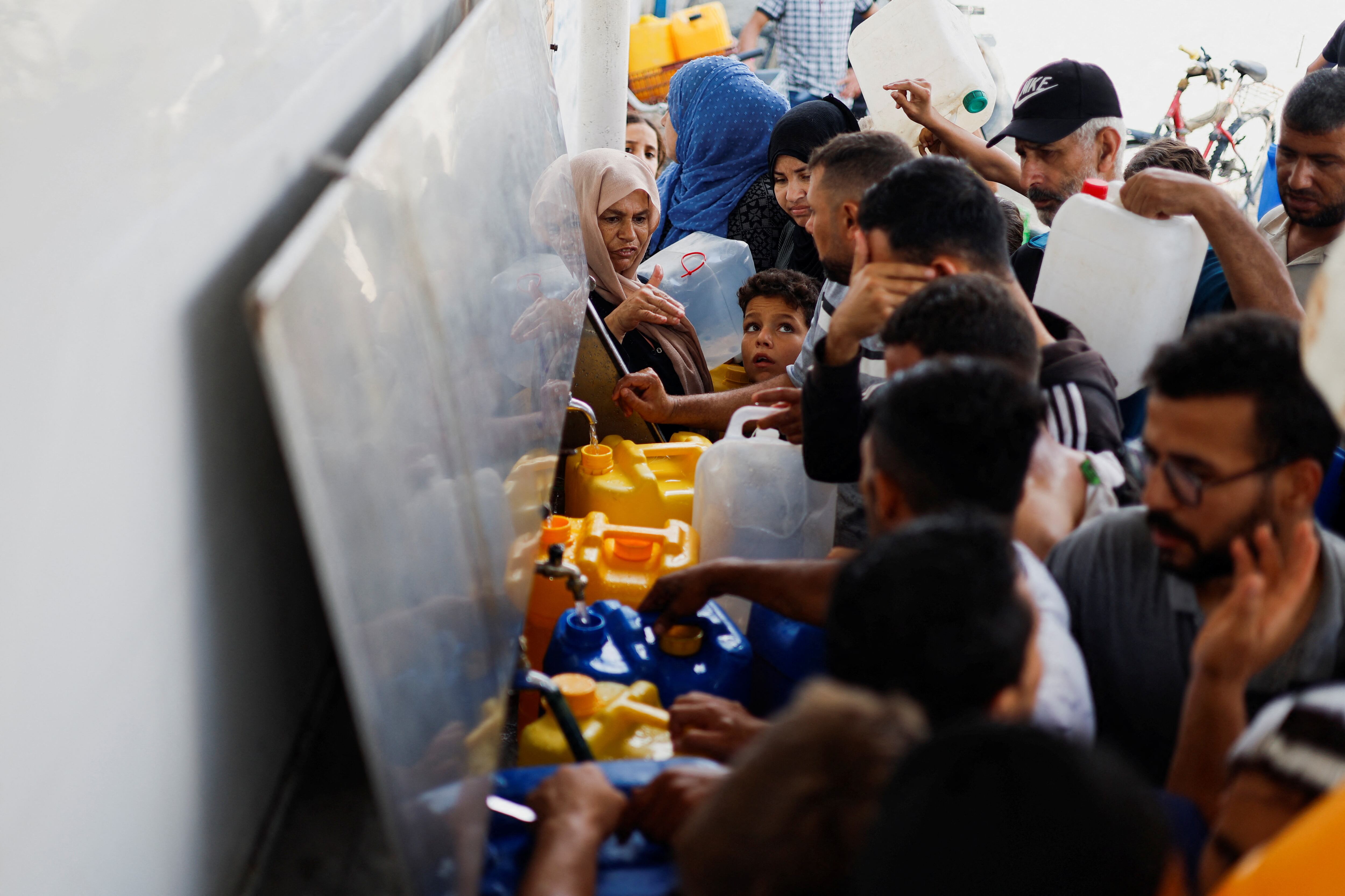 Un grupo de personas intentan llenar bidones con agua en Jan Yunis, este jueves.