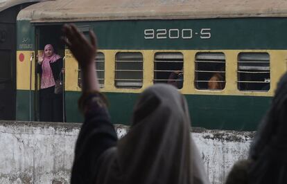 Una pasajera india abordo del Samjhauta Express, que conecta Nueva Delhi (India) y Lahore (Pakistán), saluda a una conocida cuando sale de la estación de tren de Lahore, después de que el servicio ferroviario se restaurse tras días de tensión entre ambos países.