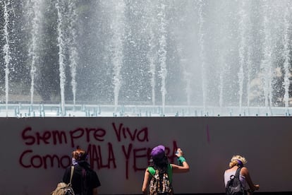 Mujeres pintan con aerosol un grafiti, durante la marcha para conmemorar el Día Internacional de la Mujer en la Ciudad de México.