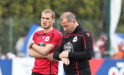 Álex Bergantiños, con secuelas tras la reconstrucción de su labio, observa el entrenamiento de sus compañeros junto al segundo entrenador Fabián Rivero.