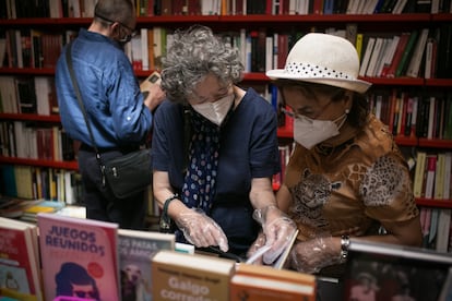 Lectoras en la librería Documenta de Barcelona el pasado mes de julio, con guantes y mascarillas, hojean un libro.