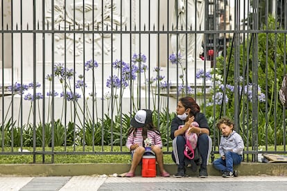 Una mujer con sus dos hijos pide ayuda en una calle de Buenos Aires, el 4 de diciembre.