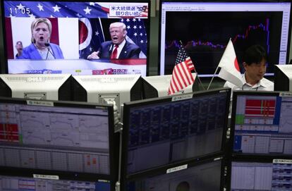 TOKYO, JAPAN - NOVEMBER 09: An employee of a foreign exchange trading company works in front of monitors displaying Democratic presidential nominee Hillary Clinton and Republican presidential nominee Donald Trump on U.S. presidential election TV news (L), and the graph of the recent fluctuations of the Japanese yen's exchange rate against the U.S. dollar at a foreign exchange trading company on November 9, 2016 in Tokyo, Japan. Americans went to the polls Tuesday to choose between Republican Donald Trump and Democrat Hillary Clinton for president. (Photo by Yuya Shino/Getty Images)