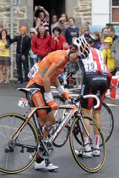 Amets Txurruka revisa la bicicleta tras una caída en el Tour de Francia.