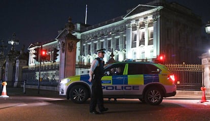 Una patrulla policial custodia el cord&oacute;n de seguridad instalado este viernes junto al palacio de Buckingham. 