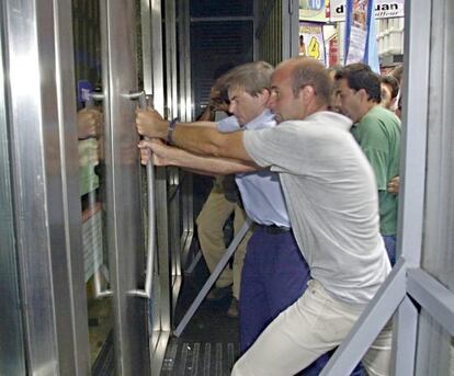 Argentinos intentan romper la puerta de un banco para entrar en él, en Buenos Aires, en febrero de 2002.
