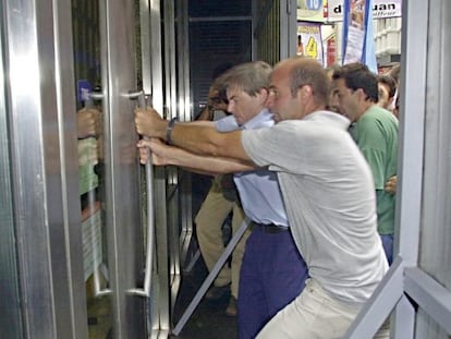 Argentinos intentan romper la puerta de un banco para entrar en él, en Buenos Aires, en febrero de 2002.