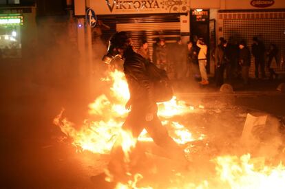 Un hombre con máscara de anti gas camina a través del fuego. Un grupo de manifestantes se enfrentaron con la policía turca durante una manifestación en la parte asiática de Estambul.