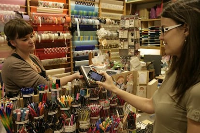A customer using her cellphone to pay in a store in Sitges.