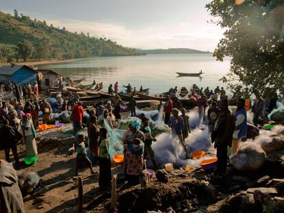 Playa del pueblo de Kasunyu, a orillas del lago Kivu. Cada día, después del amanecer, los pescadores vuelven al pueblo con sus capturas y este lugar se convierte en un mercado frenético cuando las comerciantes se reúnen alrededor de los barcos recién llegados para comprar pescado fresco que venderán en los mercados de todo el territorio. En la República Democrática del Congo y en Ruanda, centenares de miles de personas dependen del pescado del lago como fuente de proteínas cuando apenas hay otra disponible. Los pescadores, agotados tras horas de duro trabajo en el lago, aceptan el mejor precio que encuentran y preparan sus barcas y sus redes, listos para el siguiente viaje.