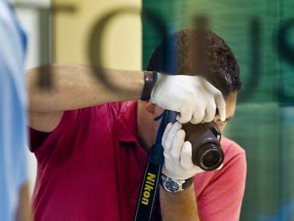 Un agente toma fotografías del interior de la joyería Tous del paseo de Gràcia tras ser atracada