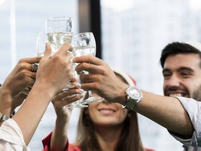 Varios compañeros brindan en la cena de empresa por Navidad.