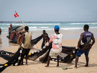 Tres jóvenes pescadores de Kayar, una ciudad costera en la región de Thiès, tiran de las redes de un cayuco de pesca que acaba de llegar a tierra. La crisis de la pesca artesanal debido a la actividad de grandes barcos extranjeros impacta sobre la emigración. Muchos de los que llegan a Canarias en cayucos son pescadores de Mbour, Kayar o Saint Louis.