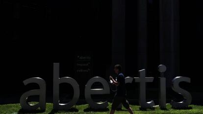 Un ciudadano pasa ante la sede de Abertis en Madrid.