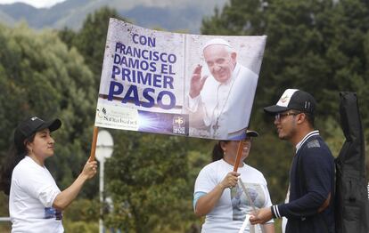 Dos mujeres sostienen un cartel con un mensaje para el papa Francisco mientras esperan su paso en la Avenida Calle 26, una de las principales vías de Bogotá (Colombia).