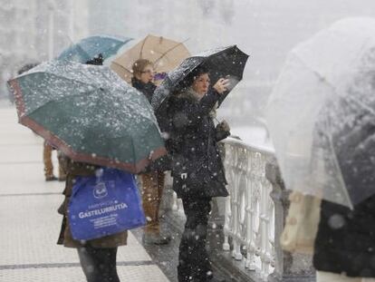 Varias personas toman imágenes en el Paseo de La Concha de San Sebastián de la última nevada caída en la ciudad el pasado mes de febrero.