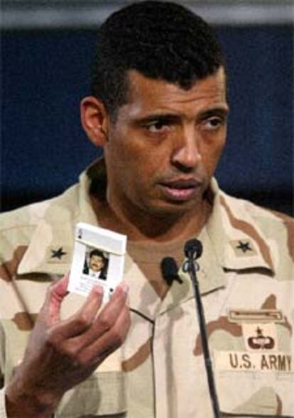 Broorks muestra un mazo de cartas con el rostro de los sospechosos, distribuido entre los soldados.