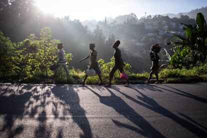 Varias mujeres caminan por el borde de una carretera hacia un mercado en Fermate, Haití.