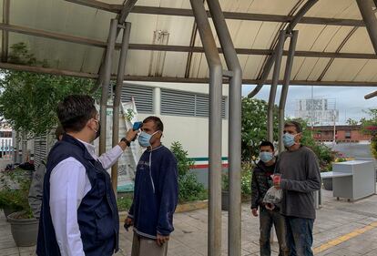 Un funcionario estatal toma la temperatura a un grupo de migrantes deportados a su llegada a Reynosa.