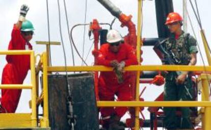 Dos trabajadores y un miembro de seguridad realizan en un pozo de extracción de petróleo, en el municipio Independencia, en la Faja del Orinoco en Venezuela. EFE/Archivo