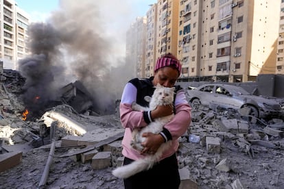 Una mujer sujeta a su gato junto a los escombros de un edificio colapsado tras un bombardeo israelí sobre Beirut, este miércoles. 