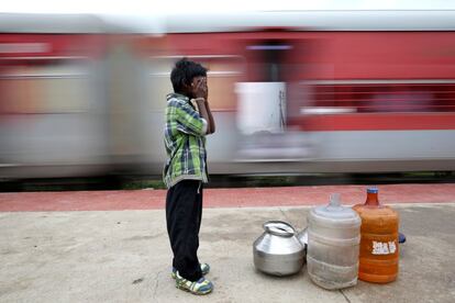 Siddharth Dhage, de 10 años, espera para abordar un tren con contenedores de agua vacíos, en la estación de tren de Mukundwadi, Aurangabad (India).