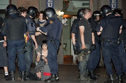 La policía pide la documentación a un grupo de "indignados" durante el desalojo de las 200 personas que permanecían en la Puerta del Sol después de la primera de las concentraciones autorizadas por la Delegación del Gobierno en Madrid, sobre las 5:00 horas.