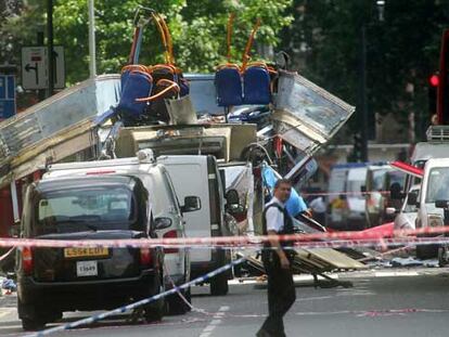 Un operario de los servicios de rescate pasa por delante del autobús destruido por una bomba cerca de Russell Square, en Londres.