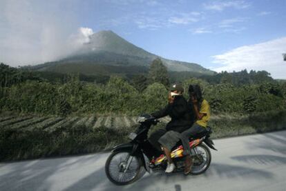 Dos hombres se protegen con mascarillas del humo del volcán.