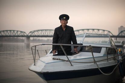 El marino Kim Il-Soo posa junto al barco que es utilizado para hacer fotos en sesiones de bodas en el río Taedong, en Pyongyang.