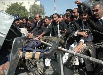 Policías pakistaníes detienen el avance de un grupo de manifestantes ayer en Lahore.