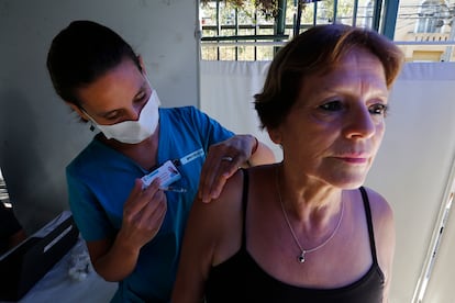 Una enfermera vacuna a una mujer contra la influenza en Santiago de Chile, en 2020.